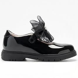 A single black patent leather Mary Jane shoe with a large black sheer bow on the side, set against a plain white background.